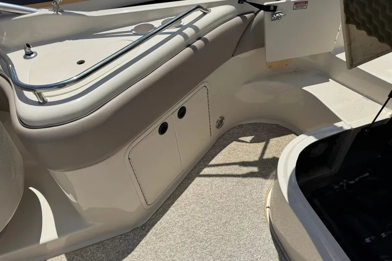 Slide: The Image of 2002 Sea Ray 240 Sundeck interior with storage compartments and seating area. - 16