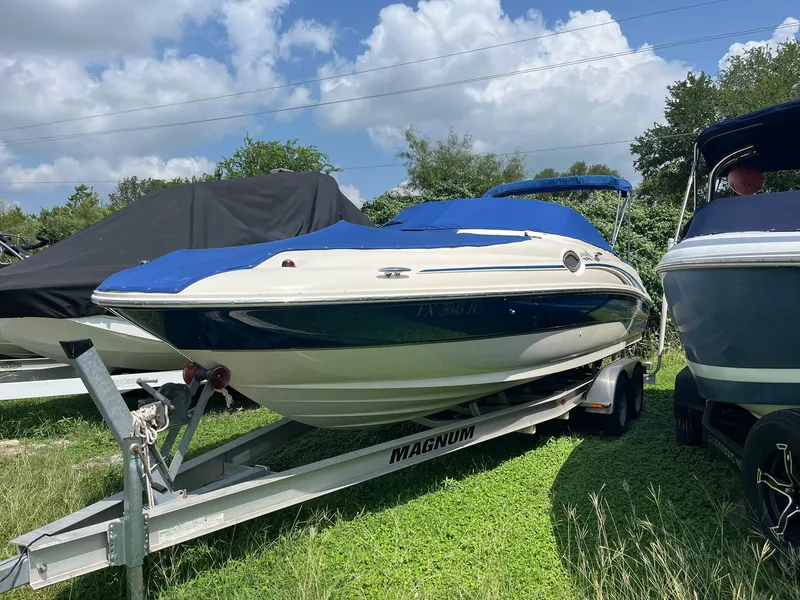 Slide: The Image of 2002 Sea Ray 240 Sundeck boat on trailer, blue cover, parked outdoors. - 4