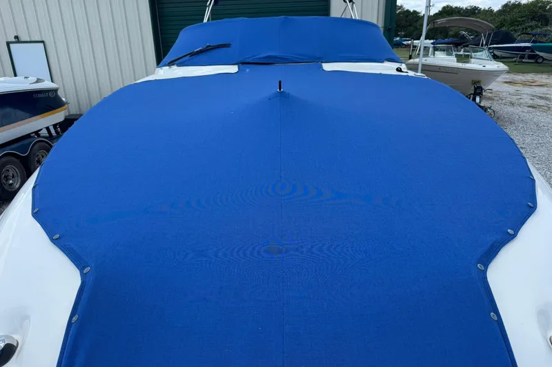 Slide: The Image of 2002 Sea Ray 240 Sundeck with blue cover in storage area. - 6