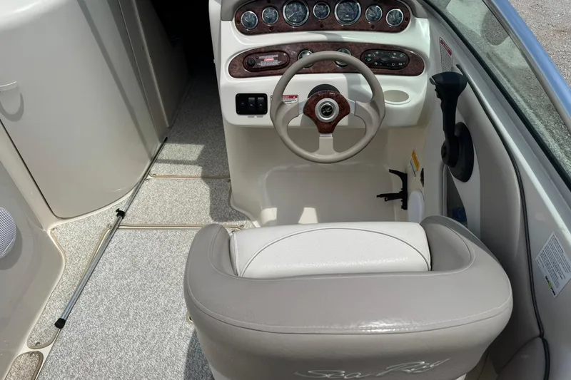 Slide: The Image of 2002 Sea Ray 240 Sundeck cockpit with steering wheel and control panel. - 7