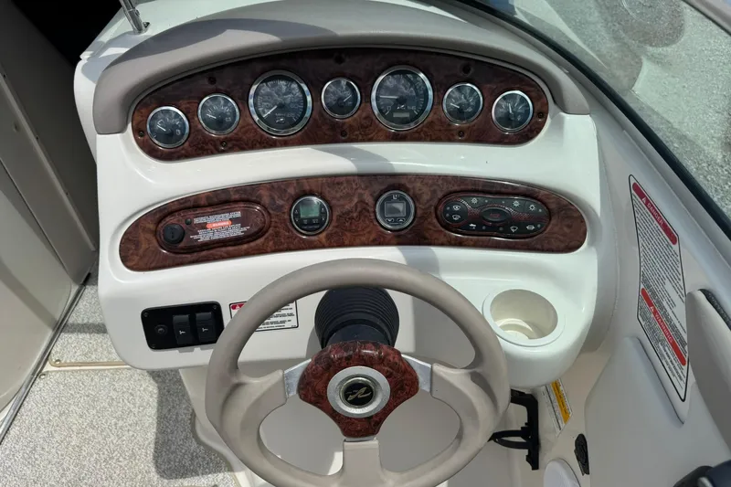 Slide: The Image of 2002 Sea Ray 240 Sundeck dashboard with gauges and steering wheel. - 8