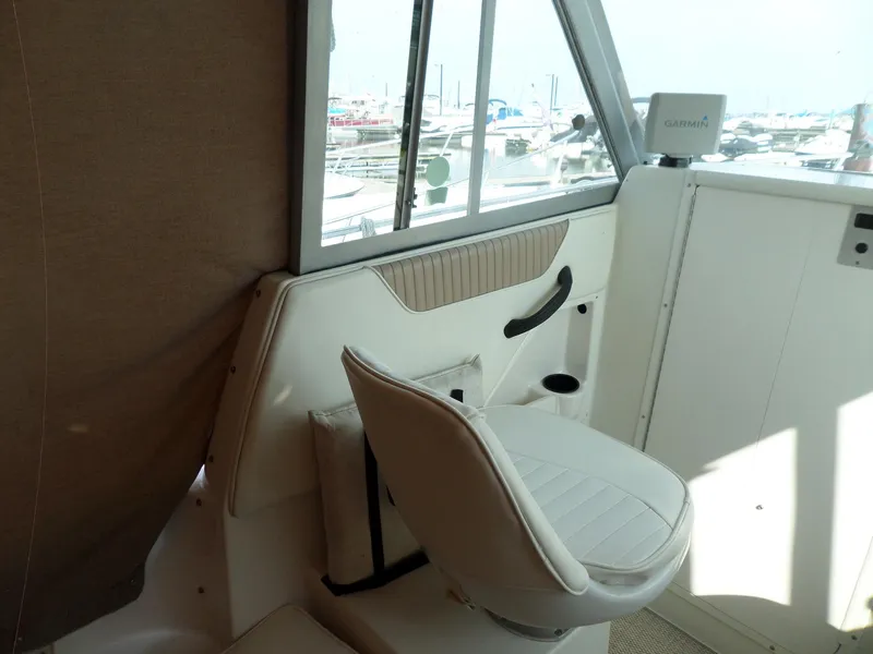 Slide: The Image of 2005 Seaswirl Striper boat interior with white seating and window view. - 10