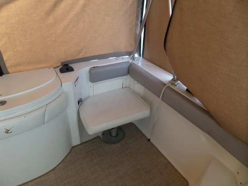 Slide: The Image of 2005 Seaswirl Striper boat interior with seating and beige curtains. - 12