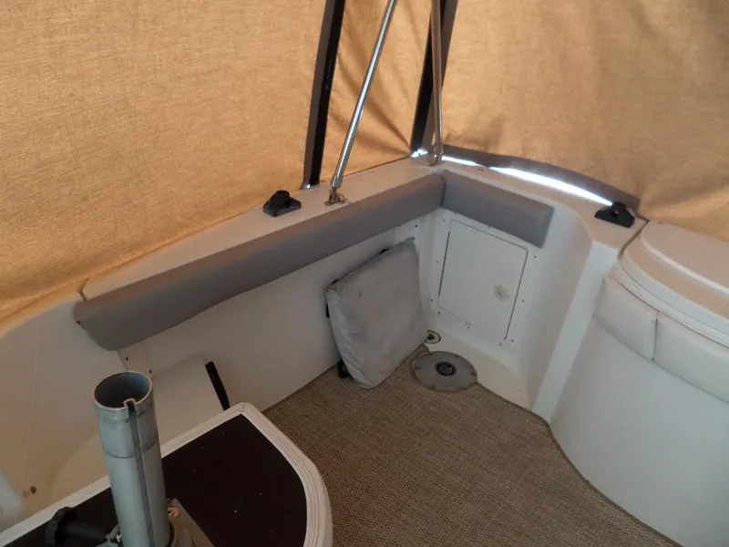Slide: The Image of 2005 Seaswirl Striper boat interior with beige upholstery and storage compartment. - 14