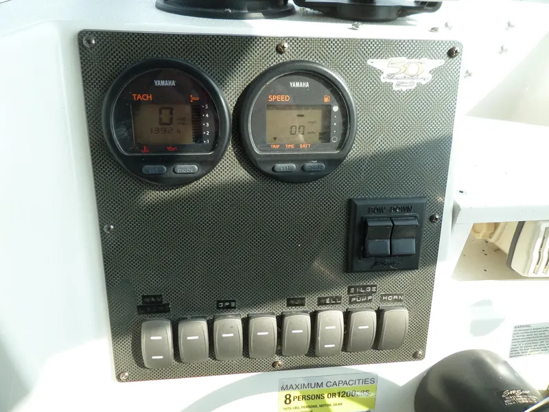 Slide: The Image of 2005 Seaswirl Striper dashboard with Yamaha tachometer and speedometer, control switches, and capacity label. - 17