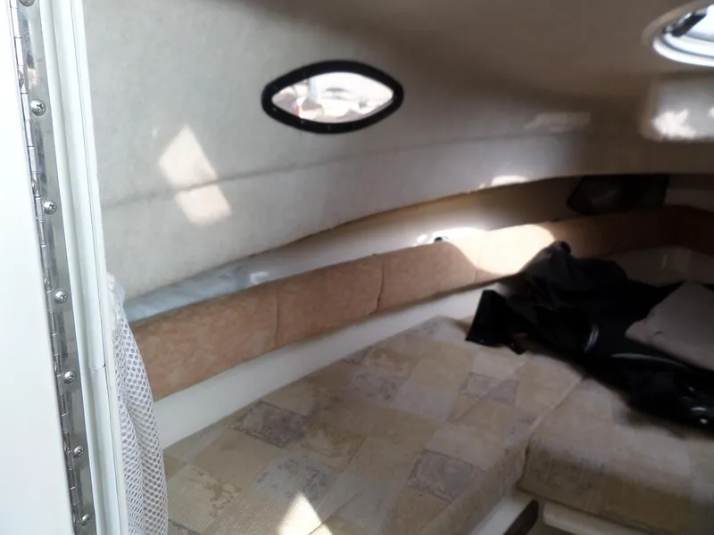 Slide: The Image of 2005 Seaswirl Striper cabin interior with cushioned seating and small windows. - 23