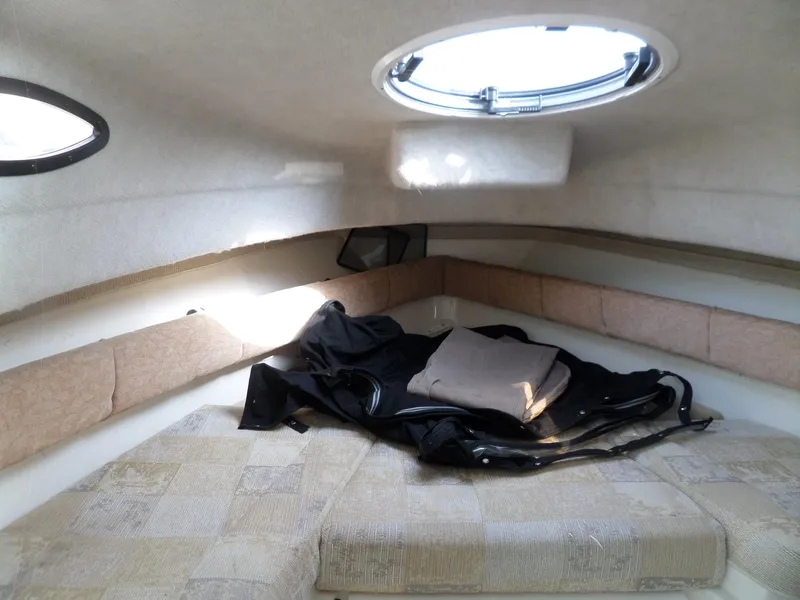 Slide: The Image of 2005 Seaswirl Striper cabin interior with bedding and porthole window. - 24