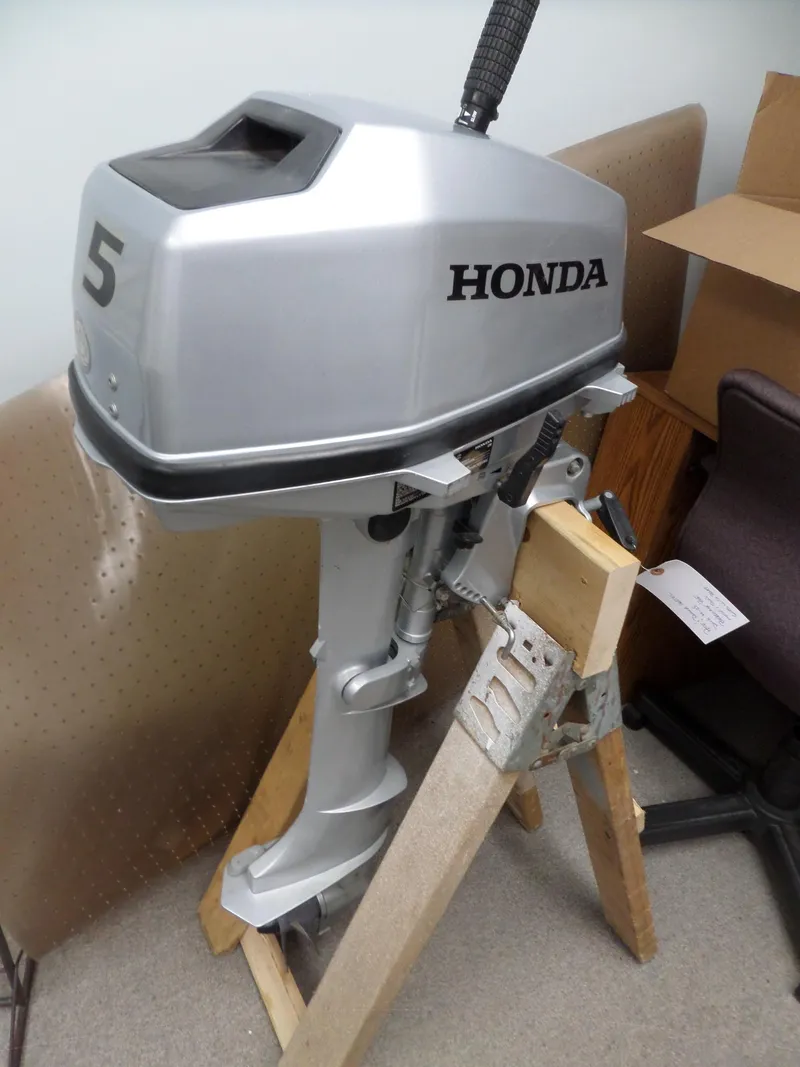 Slide: The Image of Silver Honda outboard motor on stand, model number 5, indoors. - 29