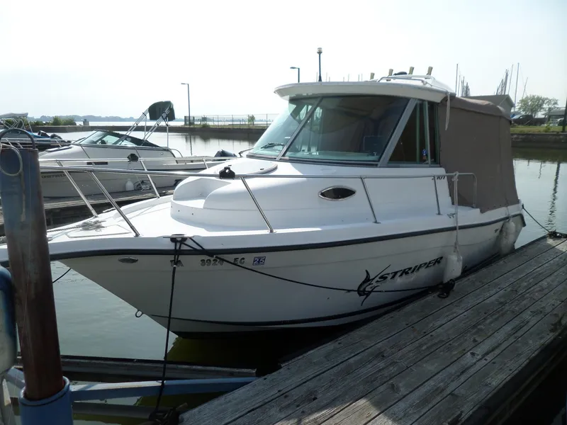 Slide: The Image of 2005 Seaswirl Striper boat docked at marina, featuring sleek design and enclosed cabin. - 5