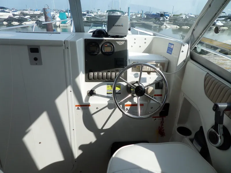 Slide: The Image of 2005 Seaswirl Striper boat cockpit with steering wheel and Garmin navigation system. - 8