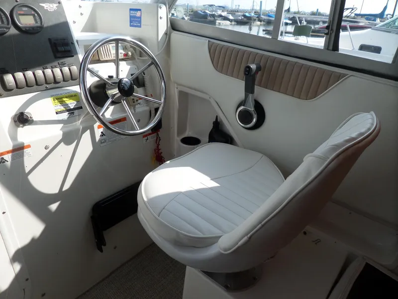 Slide: The Image of 2005 Seaswirl Striper boat interior with steering wheel and captain's chair. - 9