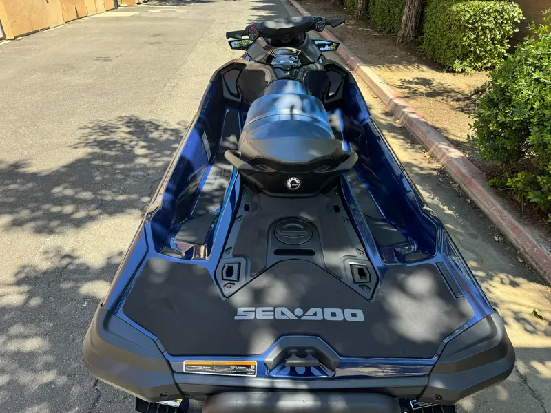 Slide: The Image of 2025 Sea-Doo GTX 230 jet ski parked on a sunny street. - 2
