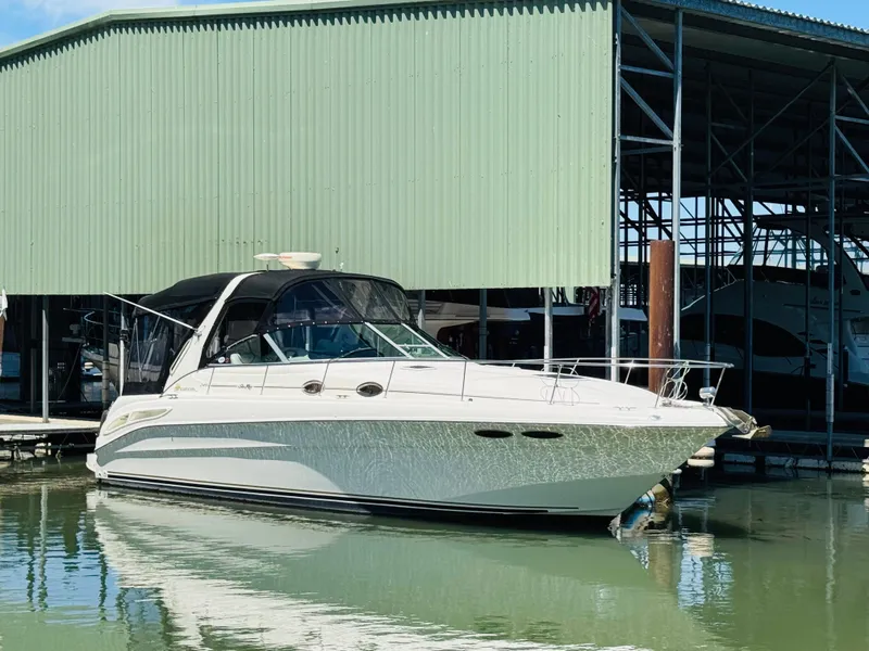 Slide: The Image of 2000 Sea Ray 340 Sundancer docked at marina, green metal building in background. - 1