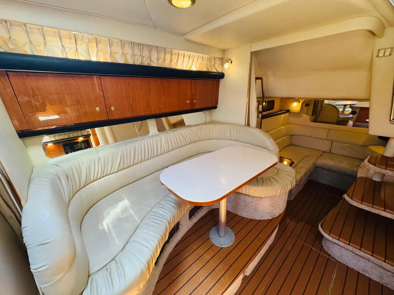 Slide: The Image of Interior of 2000 Sea Ray 340 Sundancer with plush seating and wooden cabinetry. - 25