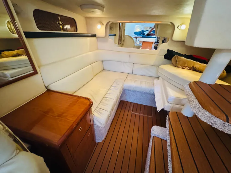 Slide: The Image of Interior of 2000 Sea Ray 340 Sundancer with cozy seating and wooden accents. - 26