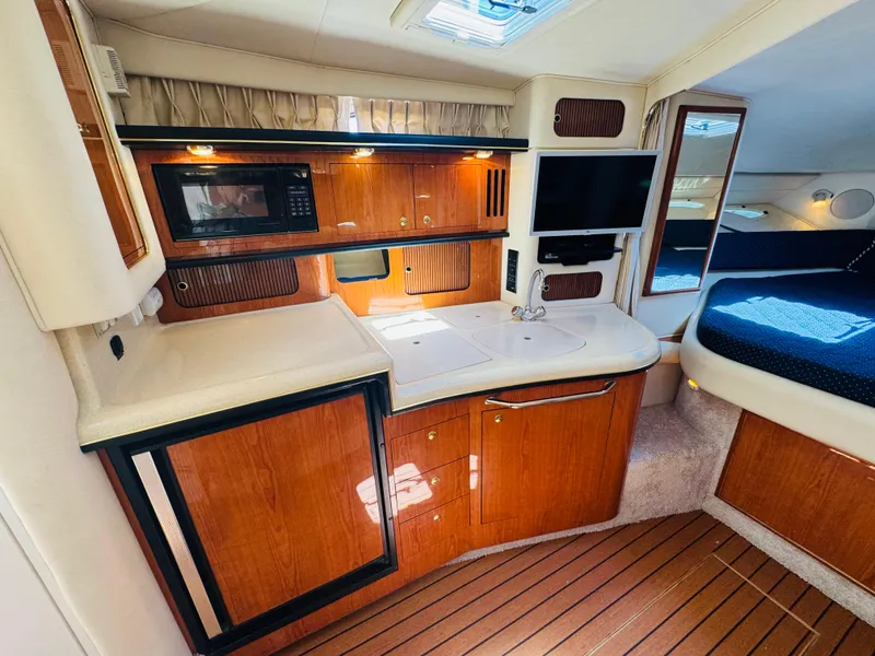 Slide: The Image of Luxurious interior of 2000 Sea Ray 340 Sundancer yacht with kitchenette and cozy sleeping area. - 28