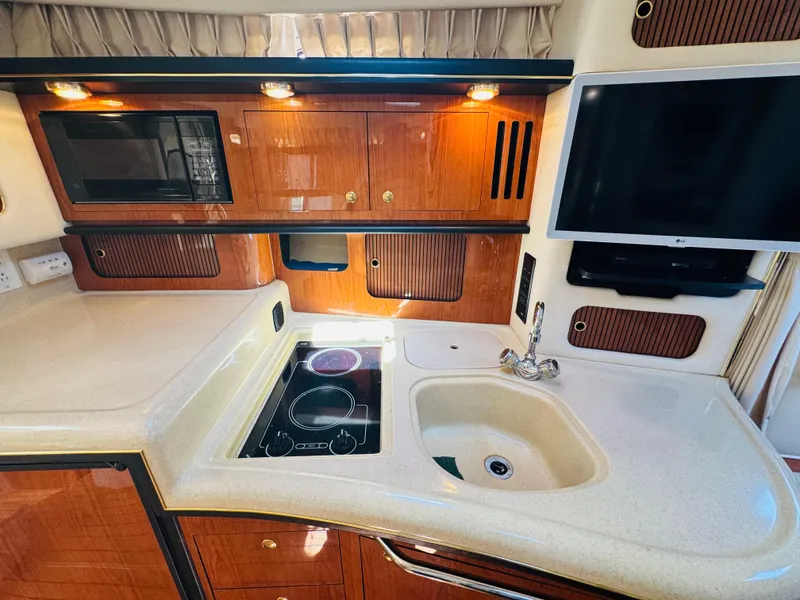 Slide: The Image of Luxurious 2000 Sea Ray 340 Sundancer yacht kitchen with modern amenities and elegant wood cabinetry. - 30