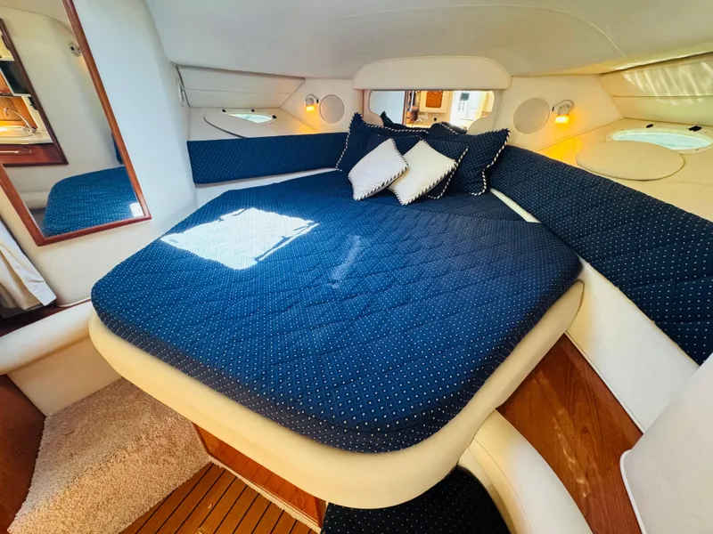 Slide: The Image of Interior cabin of 2000 Sea Ray 340 Sundancer with blue bedding and pillows. - 32