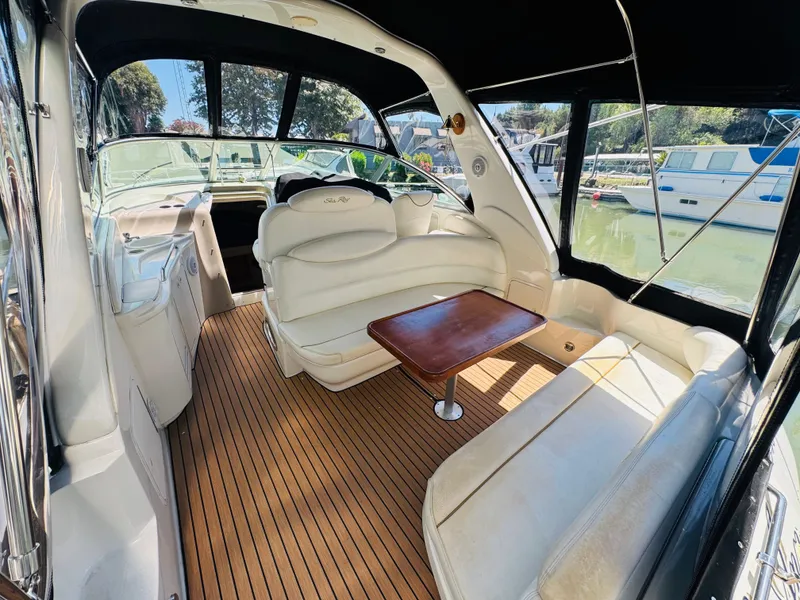 Slide: The Image of 2000 Sea Ray 340 Sundancer interior with white seating and wooden flooring. - 5