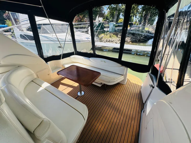 Slide: The Image of Interior of 2000 Sea Ray 340 Sundancer with seating and wooden table. - 7