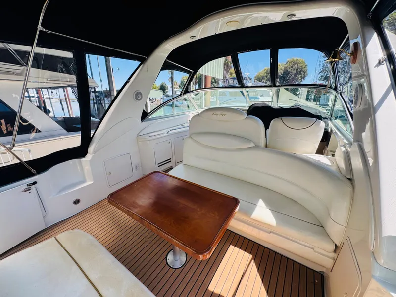 Slide: The Image of Interior of 2000 Sea Ray 340 Sundancer yacht with white seating and wooden table. - 8
