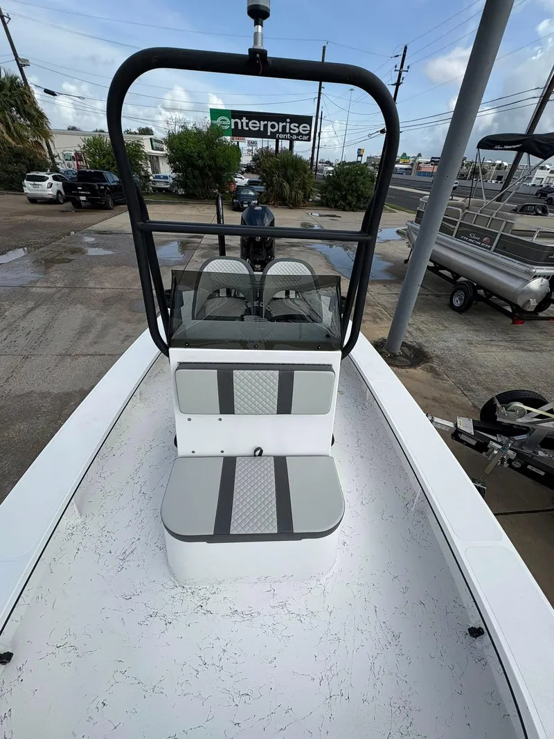 Slide: The Image of 2026 Freedom Boats USA 23' Warrior, white deck, gray seating, parked outdoors. - 12