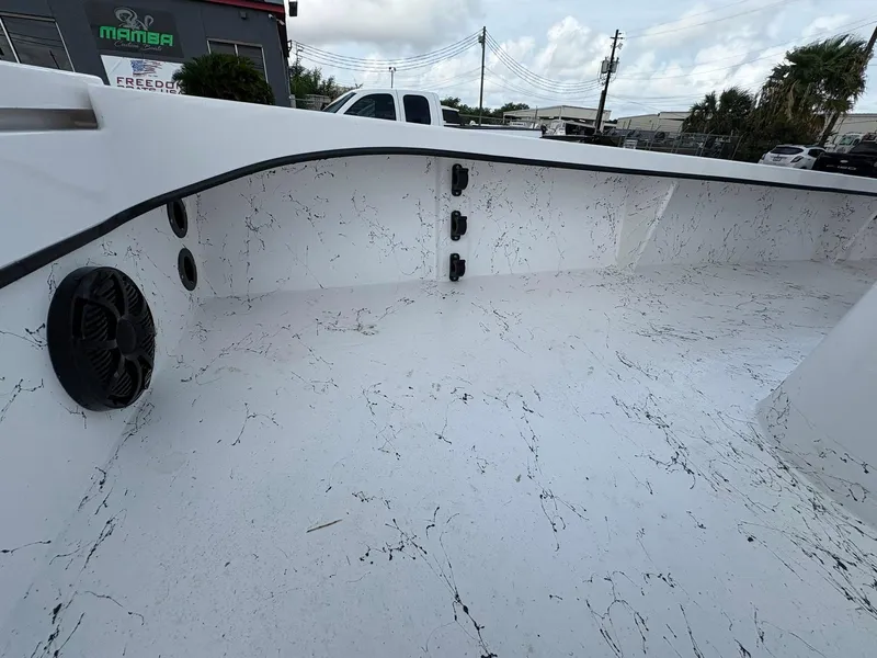 Slide: The Image of 2026 Freedom Boats USA 23' Warrior interior with sleek white design and black accents. - 19