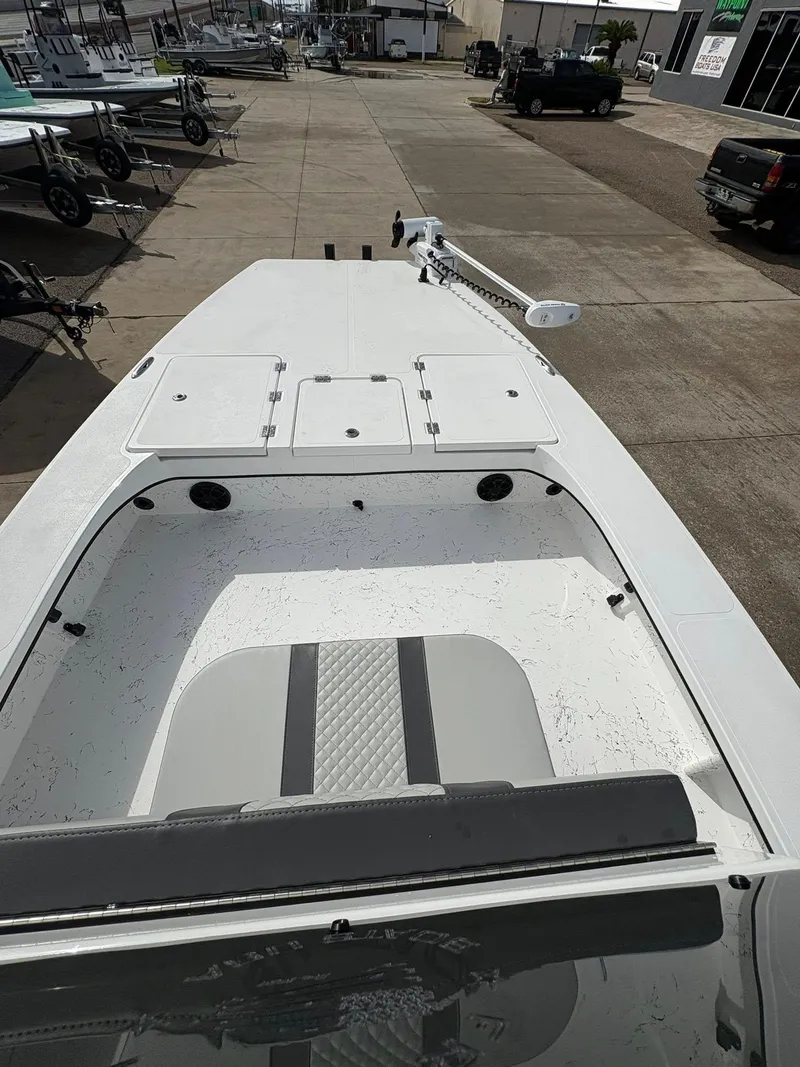 Slide: The Image of 2026 Freedom Boats USA 23' Warrior, white deck, parked on concrete lot. - 3