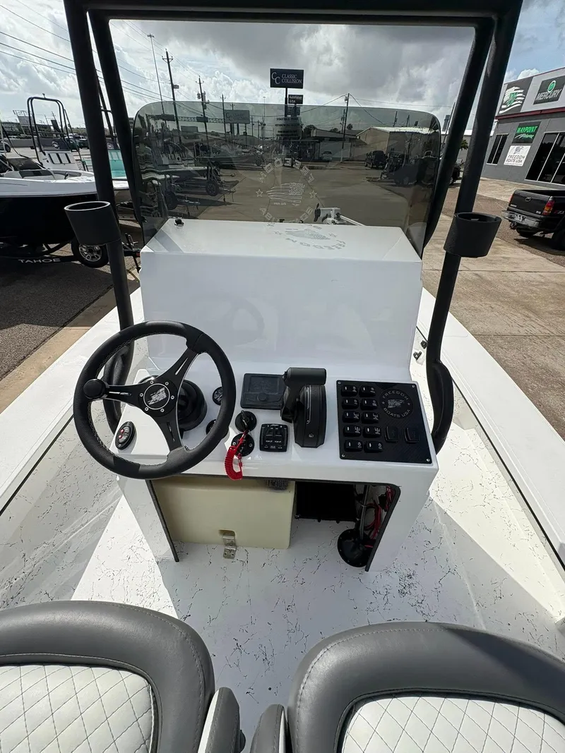 Slide: The Image of 2026 Freedom Boats USA 23' Warrior dashboard with steering wheel and controls. - 8