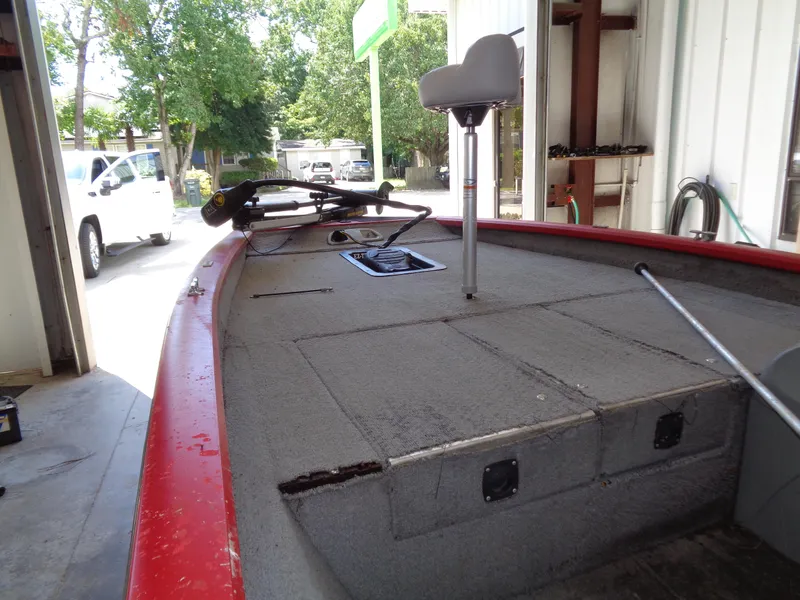 Slide: The Image of 2008 Bass Tracker PT175 boat interior with red trim, parked in a garage. - 10