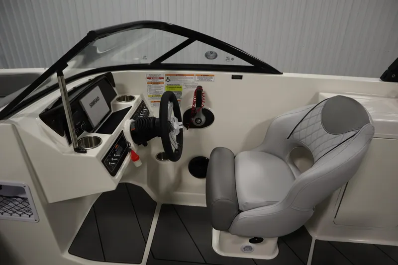 Slide: The Image of 2025 Bayliner D22I boat interior with steering wheel, dashboard, and gray captain's chair. - 10