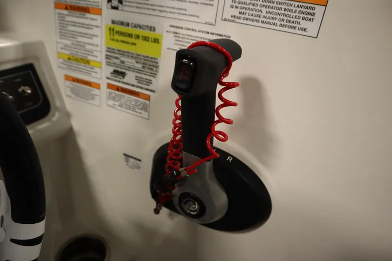 Slide: The Image of Control panel of 2025 Bayliner D22I boat with safety warnings and red coiled lanyard. - 18