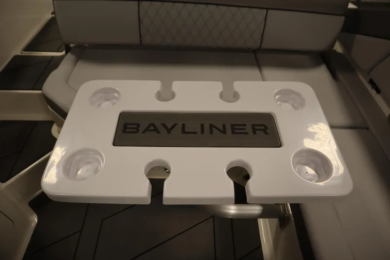Slide: The Image of 2025 Bayliner D22I boat table with cup holders and logo. - 28