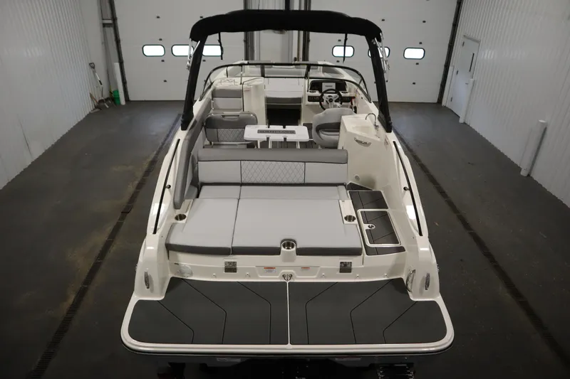Slide: The Image of 2025 Bayliner D22I boat interior with seating and helm in a garage setting. - 3