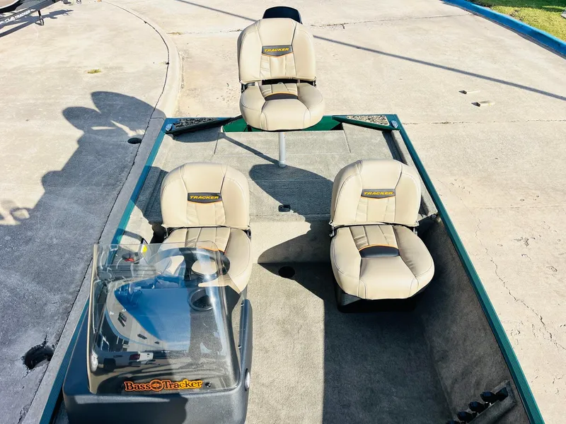 Slide: The Image of 2026 Tracker Bass Tracker Classic Limited boat with beige seats and console, parked on concrete. - 17
