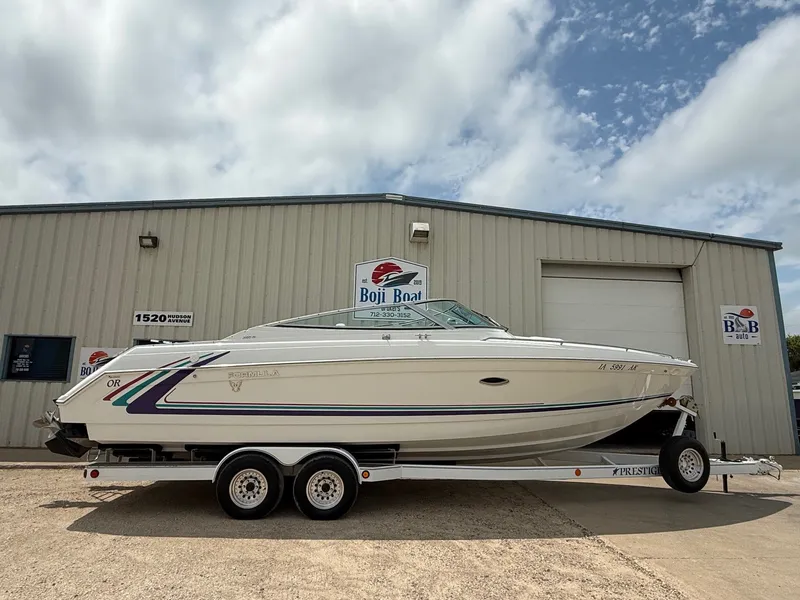 Slide: The Image of 1997 Formula 280SS boat on trailer outside Boji Boat building under cloudy sky. - 0