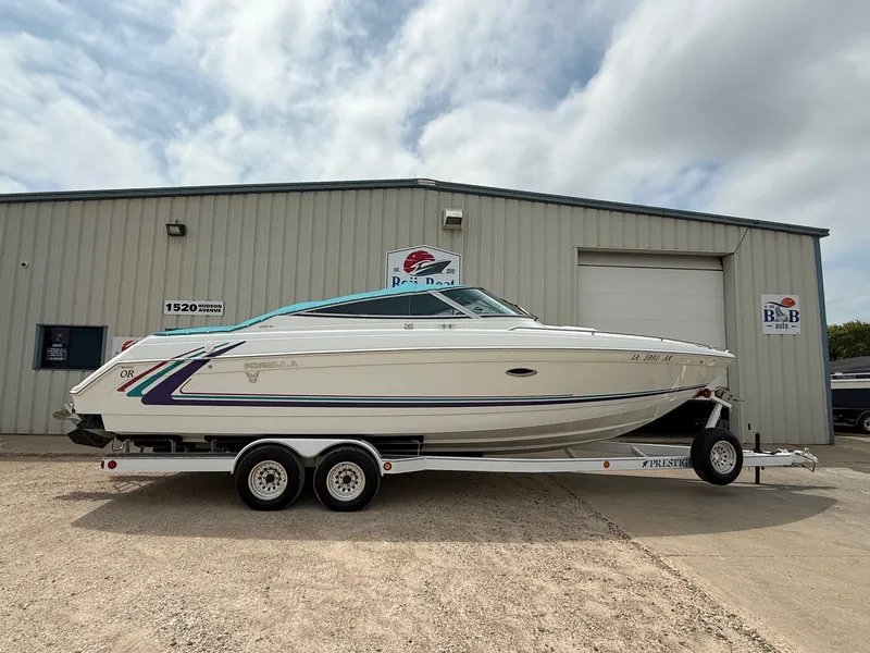 Slide: The Image of 1997 Formula 280SS boat on trailer, parked outside a metal building under a cloudy sky. - 39