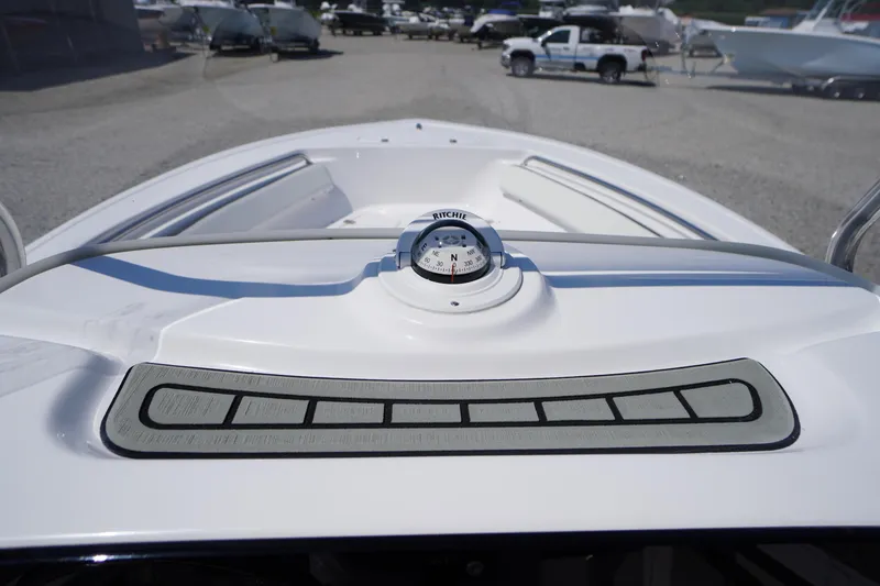 Slide: The Image of 2025 Tidewater 198 CC Adventure boat dashboard with compass, parked in a marina. - 21