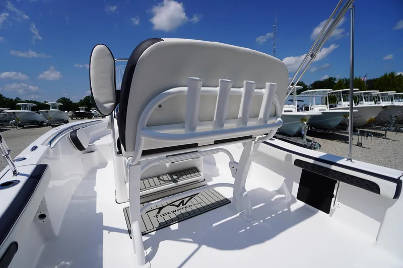 Slide: The Image of 2025 Tidewater 198 CC Adventure boat interior with seating and rod holders under a clear blue sky. - 33