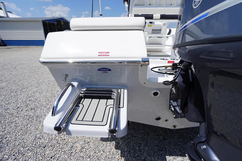 Slide: The Image of 2025 Tidewater 198 CC Adventure boat with swim platform and ladder on gravel surface. - 39
