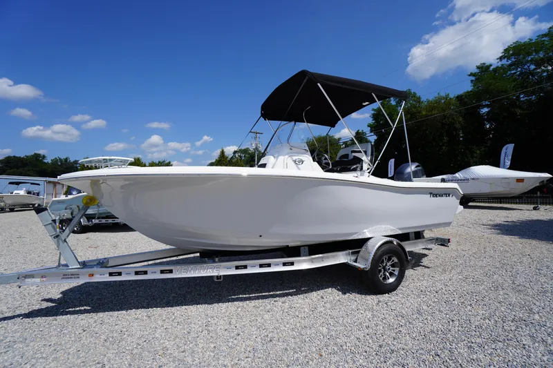 Slide: The Image of 2025 Tidewater 198 CC Adventure boat on trailer under clear blue sky. - 47