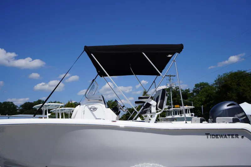 Slide: The Image of 2025 Tidewater 198 CC Adventure boat with canopy under clear blue sky. - 48