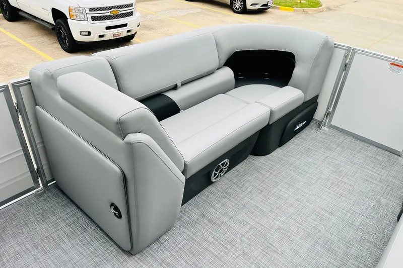 Slide: The Image of 2026 Sun Tracker Party Barge 22 DLX interior with gray seating and speaker system. - 17