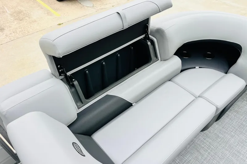 Slide: The Image of 2026 Sun Tracker Party Barge 22 DLX interior seating with storage compartment open. - 21