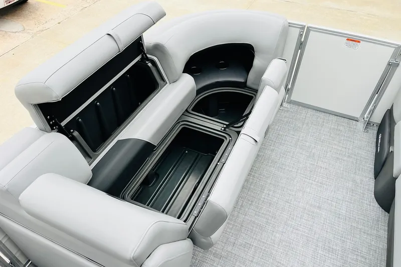 Slide: The Image of 2026 Sun Tracker Party Barge 22 DLX interior with open storage compartments and gray seating. - 22