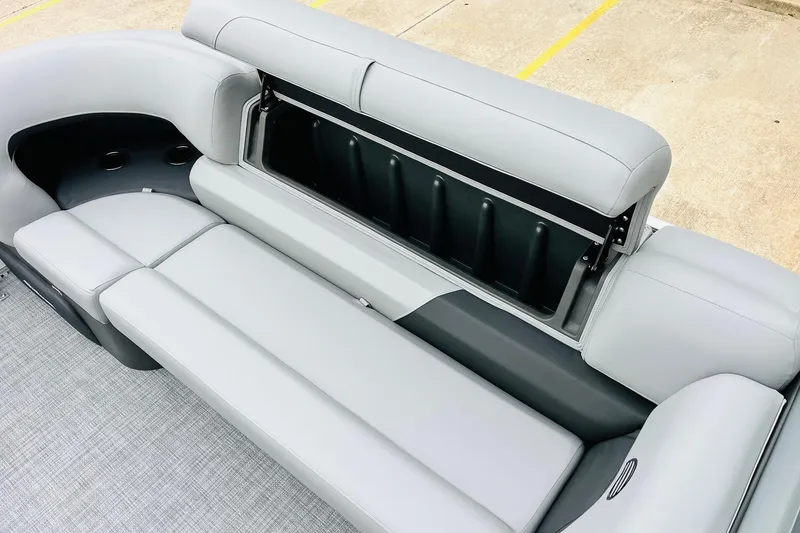 Slide: The Image of 2026 Sun Tracker Party Barge 22 DLX seating with storage compartment open. - 26