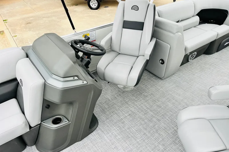 Slide: The Image of 2026 Sun Tracker Party Barge 22 DLX interior with gray seating and steering console. - 30