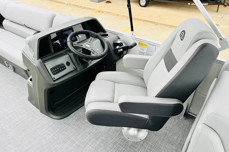 Slide: The Image of 2026 Sun Tracker Party Barge 22 DLX helm with comfortable captain's chair and modern controls. - 31