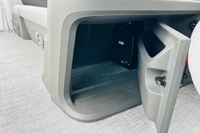 Slide: The Image of 2026 Sun Tracker Party Barge 22 DLX storage compartment with open door. - 34