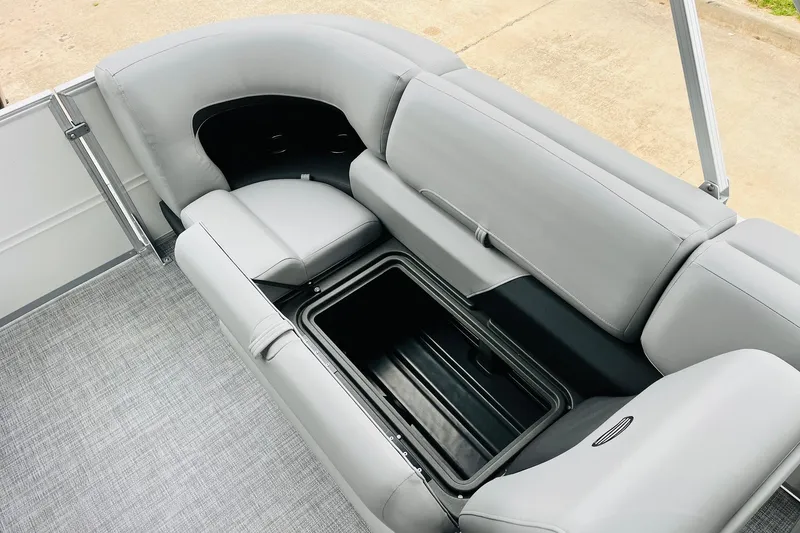 Slide: The Image of 2026 Sun Tracker Party Barge 22 DLX with open storage compartment and gray seating. - 38